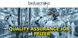 Quality Assurance Job at Pfizer | BSc & MSc Biotech Candidates Apply Now Quality Assurance Job at Pfizer BSc & MSc Biotech Candidates Apply Now. A promotional job banner with the Biotecnika logo at the top. Large yellow and white text reads: 'QUALITY ASSURANCE JOB at PFIZER'. The background is a photograph of a person in a full cleanroom suit and goggles, scanning equipment in a state-of-the-art pharmaceutical manufacturing lab. A turquoise 'APPLY NOW' button is at the bottom.