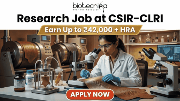 Research Job at CSIR-CLRI Earn Up to ₹42,000 + HRA Research Job at CSIR-CLRI Earn Up to ₹42,000 + HRA. A promotional banner advertisement from Biotecnika, titled "Research Job at CSIR-CLRI", featuring a prominent gold banner with text that reads: "Earn Up to ₹42,000 + HRA". The main image shows a female scientist in a lab coat, safety glasses, and blue gloves, using a stereo microscope to analyze a textured material sample (likely a leather sample, given CLRI's focus). She is at a laboratory bench equipped with other microscopes, glass apparatus with samples, chemical bottles, and a computer monitor showing data. In the background are larger industrial lab machines. The Biotecnika "Your Bio Resource" logo is at the top center. At the bottom, a red button with white text reads: "APPLY NOW".