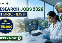 Research Jobs at BRIC-IBSD | Walk-In Interview for Life Science Candidates Research Jobs at BRIC-IBSD Walk-In Interview for Life Science Candidates. A professional recruitment banner for biotecnika advertising "Research Jobs 2026 at BRIC-IBSD." The top left features the biotecnika logo, and the headline text is prominent in blue and green. A circular blue callout on the left highlights the compensation: "Earn Upto ₹58,000 + HRA/ Month." On the right, a focused female scientist of professional and realistic appearance, wearing a white lab coat and safety glasses, is seated at a modern lab desk, using a pipette to fill a microplate. In the background, computer monitors display complex data including molecular structures and "Bioresource mapping" on a world map. Through a large window, a scenic modern building, perhaps the BRIC-IBSD institute, is visible in a lush environment. Two hexagonal icons on the far right show a network diagram over fresh produce and a sustainability tree icon. A prominent green "APPLY NOW" button with an arrow is at the bottom left.