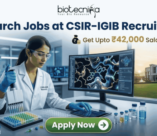 Exciting Research Jobs at CSIR-IGIB | Get Upto ₹42,000 Salary/ Month Research Jobs at CSIR-IGIB Recruitment Get Upto ₹42,000 Salary Month. A promotional banner for research jobs at CSIR-IGIB. At the top, the Biotecnika logo and the headline "Research Jobs at CSIR-IGIB Recruitment" are shown. Below, the salary details "Get Upto ₹42,000 Salary/ Month" are highlighted. The central image shows a female scientist in a lab working with a pipette, next to a monitor displaying a 3D molecular protein structure. Through a window, a modern CSIR-IGIB campus building is visible. A green "Apply Now" button is at the bottom.