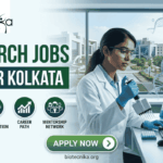 Research Jobs at IISER Kolkata. A professional recruitment banner for "Research Jobs at IISER Kolkata," featuring the Biotecnika logo at the top left. On the right, a female scientist wearing safety glasses and blue gloves is using a multichannel pipette at a lab bench. Next to her is a curved monitor displaying advanced data and molecular visualizations, with a 3D DNA helix floating in the foreground. The left side features the bold headline "RESEARCH JOBS AT IISER KOLKATA" and four circular icons highlighting: Innovative Bio-sciences, Global Collaboration, Career Path, and Mentorship Network. The background through a large window provides a realistic view of the IISER Kolkata campus buildings. A prominent green "Apply Now" button and the website "biotecnika.org" are located at the bottom.
