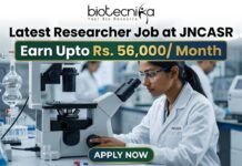 Latest Researcher Job at JNCASR | Earn Upto Rs. 56,000/ Month Researcher Job at JNCASR 2026 Life Science Career. An advertisement banner for a Researcher Job at JNCASR, featuring a female scientist in a lab coat using a microscope in a laboratory. Key text states: "Latest Researcher Job at JNCASR", "Earn Upto Rs. 56,000/ Month", with a prominent "APPLY NOW" button at the bottom and a "biotecnika" logo at the top.