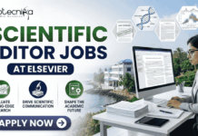 Scientific Editor Jobs at Elsevier | PhD Candidates Apply Now! Scientific Editor Jobs at Elsevier | PhD Candidates Apply Now! A professional featured image for "Scientific Editor Jobs at Elsevier" featuring the Biotecnika logo at the top left. On the right, a woman in a grey business blazer is seated at a desk, focused on a computer screen showing an edited research manuscript. The left side displays the bold headline "SCIENTIFIC EDITOR JOBS AT ELSEVIER" along with three icons representing research evaluation, scientific communication, and shaping the academic future. The background includes floating scientific diagrams and a scenic coastal building view, with a prominent "Apply Now" button at the bottom.