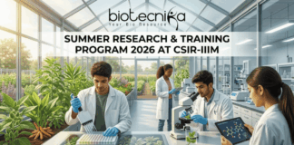 Summer Research & Training Program 2026 At CSIR-IIIM | Limited Seats for Life Science Students Summer Research & Training Program 2026 at CSIR-IIIM. A featured image for a job page set in a sunlit, modern research greenhouse. The interior is filled with flourishing green plants in raised beds. Four scientists in white lab coats are working among the flora. In the foreground, a South Asian man uses a pipette with a microplate on an illuminated screen-table. Beside him, another man holds a tablet displaying a linked molecular model near a microscope. In the background, a Black woman and another scientist work further back among lab equipment and plants. Light streams in through the glass walls and roof. The 'biotecnika Your Bio Resource' logo is at the top center. Large text on a central dark band reads: 'SUMMER RESEARCH & TRAINING PROGRAM 2026 AT CSIR-IIIM'. An orange button at the bottom center reads: 'APPLY NOW'. The overall scene is bright, collaborative, and scientifically focused.