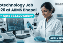Biotechnology Job 2026 at AIIMS Bhopal with ₹33,600 Salary – Apply Now! Biotechnology Job 2026 at AIIMS Bhopal with ₹33,600 Salary – Apply Now! A corporate-style job featured image banner (1280x720) for "Biotechnology Job 2026 at AIIMS Bhopal" featuring the Biotecnika CRO logo at the top right. On the left, the main headline and a bright teal highlight bar reading "Earn Upto ₹33,600 Salary" are prominently displayed. The right side features a realistic, smiling young Indian female scientist in a white lab coat and blue gloves carefully using a pipette over a well plate in a modern medical laboratory. A computer monitor showing molecular structures is visible in the background, and a glowing teal "APPLY NOW" button sits at the bottom right.