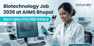Biotechnology Job 2026 at AIIMS Bhopal with ₹33,600 Salary – Apply Now! Biotechnology Job 2026 at AIIMS Bhopal with ₹33,600 Salary – Apply Now! A corporate-style job featured image banner (1280x720) for "Biotechnology Job 2026 at AIIMS Bhopal" featuring the Biotecnika CRO logo at the top right. On the left, the main headline and a bright teal highlight bar reading "Earn Upto ₹33,600 Salary" are prominently displayed. The right side features a realistic, smiling young Indian female scientist in a white lab coat and blue gloves carefully using a pipette over a well plate in a modern medical laboratory. A computer monitor showing molecular structures is visible in the background, and a glowing teal "APPLY NOW" button sits at the bottom right.