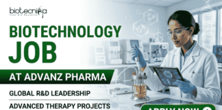 Hybrid Biotechnology Job At ADVANZ PHARMA Apply Before It's Gone! A professional promotional banner for a "Biotechnology Job at ADVANZ PHARMA." The top left features the Biotecnika logo. The bold main header on the left reads "BIOTECHNOLOGY JOB AT ADVANZ PHARMA" in a clean green and dark gray font layout, followed by two bullet points: "GLOBAL R&D LEADERSHIP" and "ADVANCED THERAPY PROJECTS". On the right side, a female researcher in a white lab coat, safety glasses, and blue gloves holds a digital tablet while carefully using a pipette with a benchtop laboratory bioreactor. The background shows a bright, modern, high-tech pharmaceutical research laboratory. A prominent dark green "APPLY NOW" button with a white right-pointing arrow sits at the bottom right.
