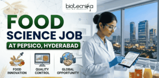 PepsiCo R&D Hiring in Hyderabad Food Science Job You Shouldn’t Miss! A promotional banner with a light background on the left and a lab scene on the right. Main title text at the top reads: "FOOD SCIENCE JOB AT PEPSICO, HYDERABAD". The top-left features the "biotecnika" logo. Below the title on the left are three colored icons labeled: "FOOD INNOVATION" (bowl of grains), "QUALITY CONTROL" (computer monitor), and "GLOBAL OPPORTUNITY" (world globe with buildings). A prominent gold "APPLY NOW" button with a right arrow is below the icons. A female scientist in a lab coat, safety glasses, and blue gloves holds a tablet on the right. She stands next to beakers containing liquids and a computer monitor, with a large window in the background showing a view of a city skyline (Hyderabad) at night.
